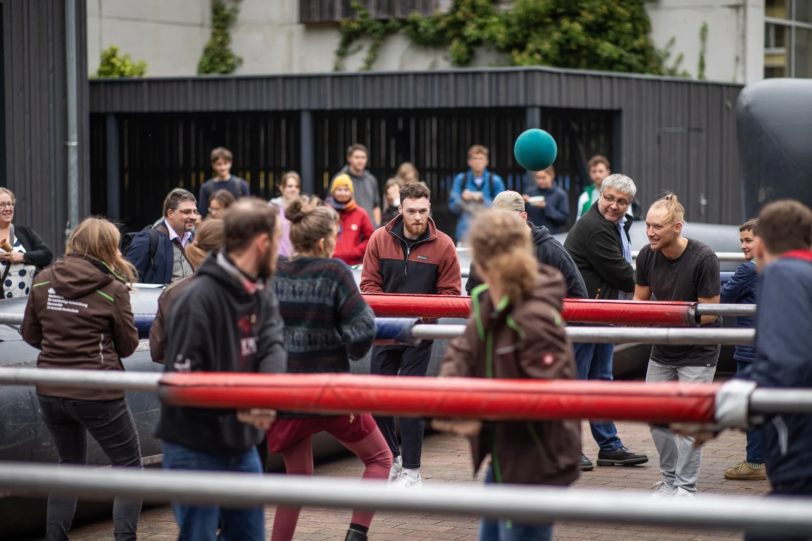 verschiedene Menschen beteiligen sich am Human-Table-Soccer, Tischkicker in Lebensgröße