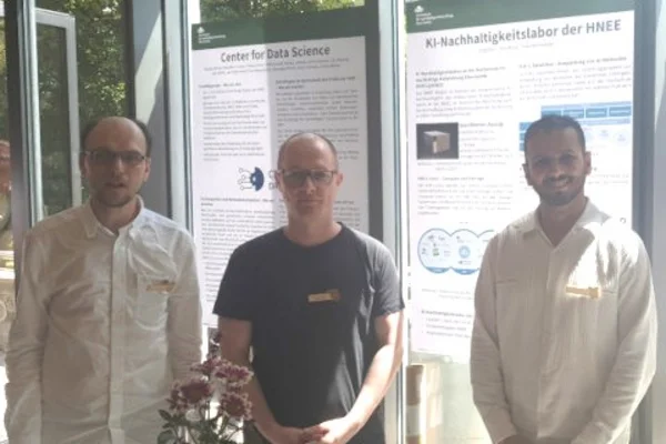 Three people stand in front of their posters on the topic of AI and data science
