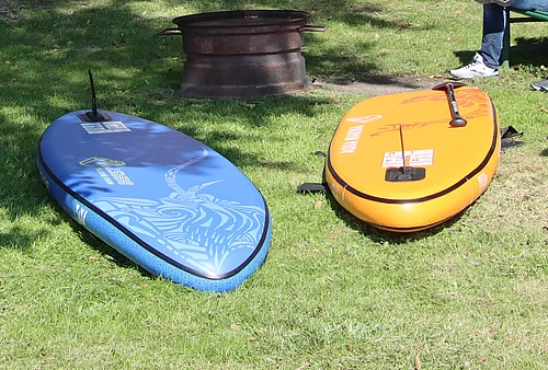 Zwei SUPs liegen im Gras.