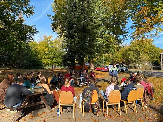 Menschen sitzen draußen im Kreis