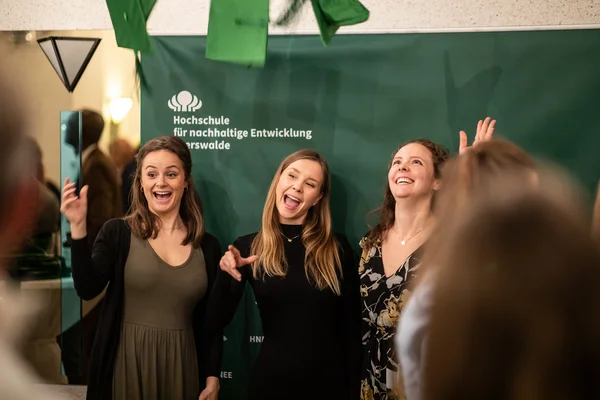 Drei Absolvent*innen schmeißen ihren Graduation-Hut in die Luft.