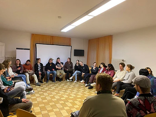 Menschen sitzen im Kreis