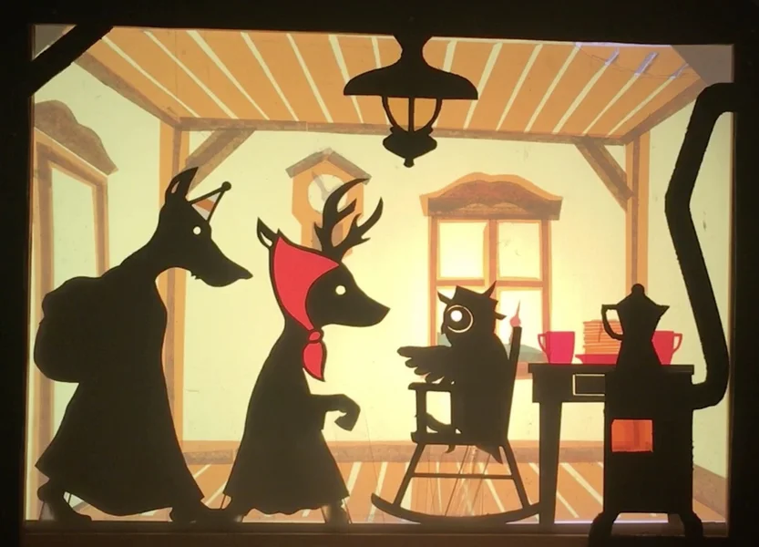 ein Scherenschnitt von Rotkäppchen und dem Wolf