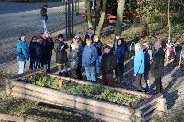 Eine gruppe von Menschen steht um ein Hochbeet. Eine Frau referiert zu dem Projekt.