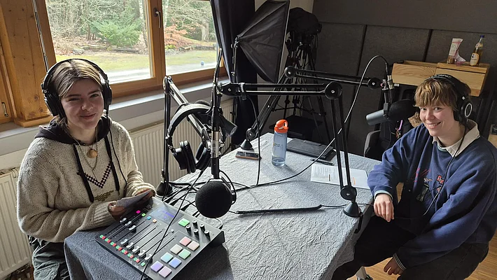 Zwie Menschen nehmen einen Podcast auf