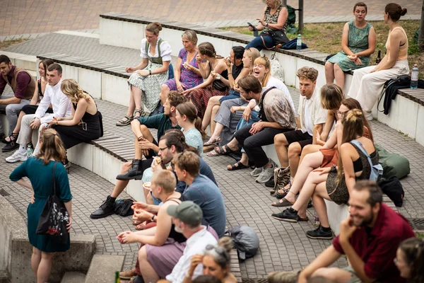 Viele Menschen sitzen feierlich gekleidet auf den Stufen eines Amphitheaters