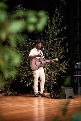 Mann mit Gitarre auf der Bühne