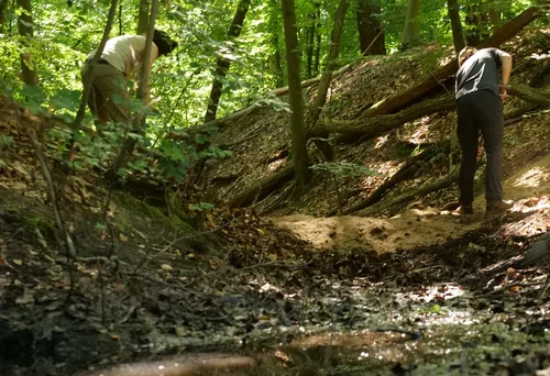 Zwei Personen laufen durch das Moor und betrieben dort Wiedervernässung.