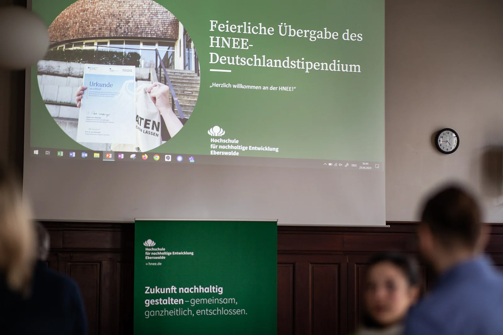 Auf einer Leinwand erscheint die Startfolie der Präsentation zur vergabe der Deutschlandstipendien an der HNE Eberswalde.
