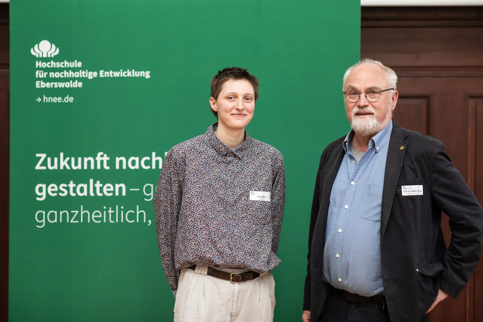 Der Präsident der EHG und die Deutschlandstipendiatin stehen vor dem Banner der Hochschule.